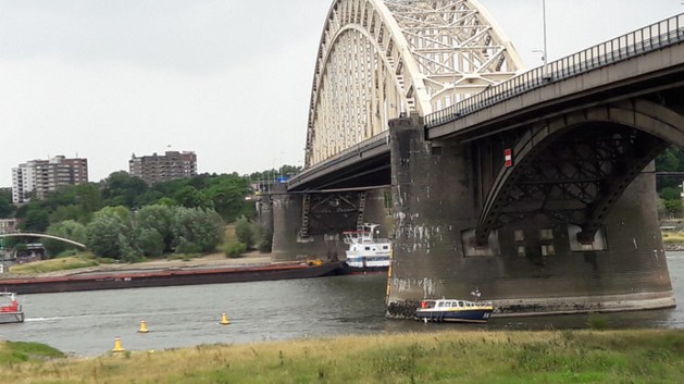 Boot strandt onder brug, reddingsteam in helikopter onderweg