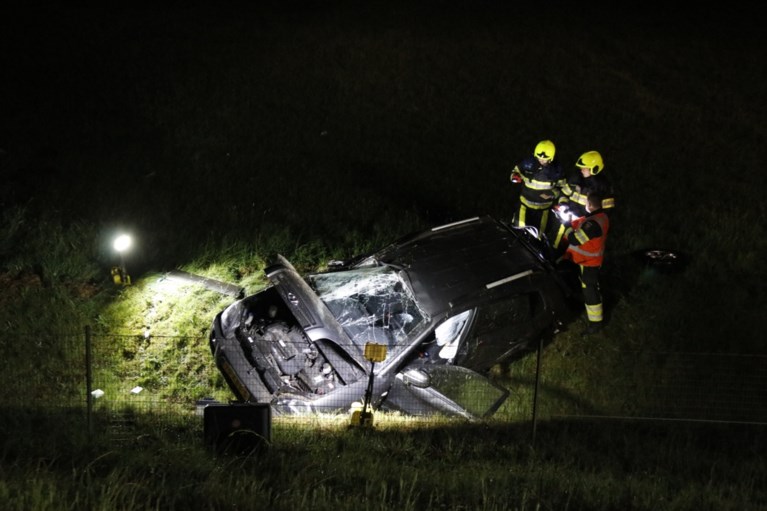 Auto raakt van de weg en valt langs talud omlaag