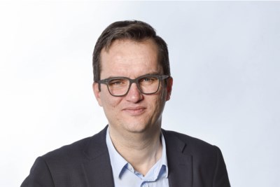 ‘Onder zijn blote man boobs puilt een al even bloot buikje pontificaal over de rand van de ruime zwembroek’