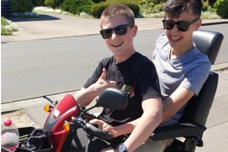 Twee bebrilde pikkies op een scootmobiel verjagen het coronaspook