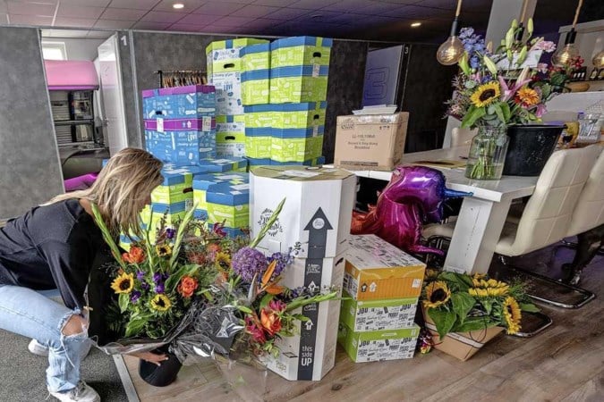 Familie van genderneutrale Frédérique overspoeld met kaarten, bloemen en ballonnen als steunbetuiging