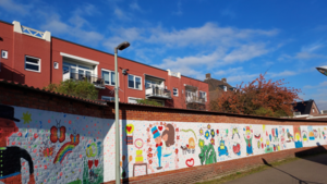 Ruzie over vijftig meter lange schildering van kinderen op muur in Beek: ‘Ons is niet om toestemming gevraagd’