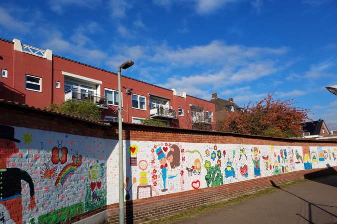 Ruzie over vijftig meter lange schildering van kinderen op muur in Beek: ‘Ons is niet om toestemming gevraagd’