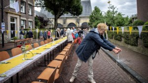 350 mensen uit Eygelshoven trotseren de weergoden en gaan buiten aan tafel om eeuwfeest Grote Kerk te vieren